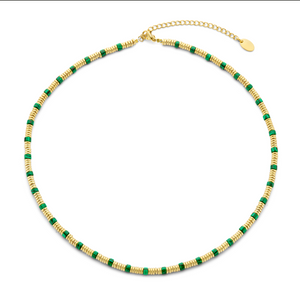 Ketting met goudkleurige kralen en rode steen