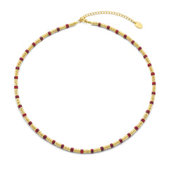 Ketting met goudkleurige kralen en rode steen